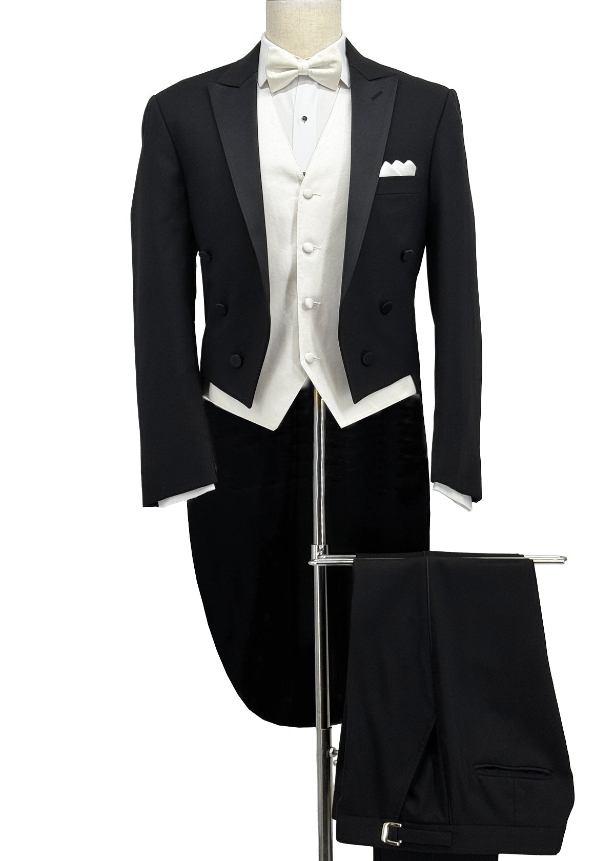 Black tails tuxedo with black pants, white bowtie and white vest.