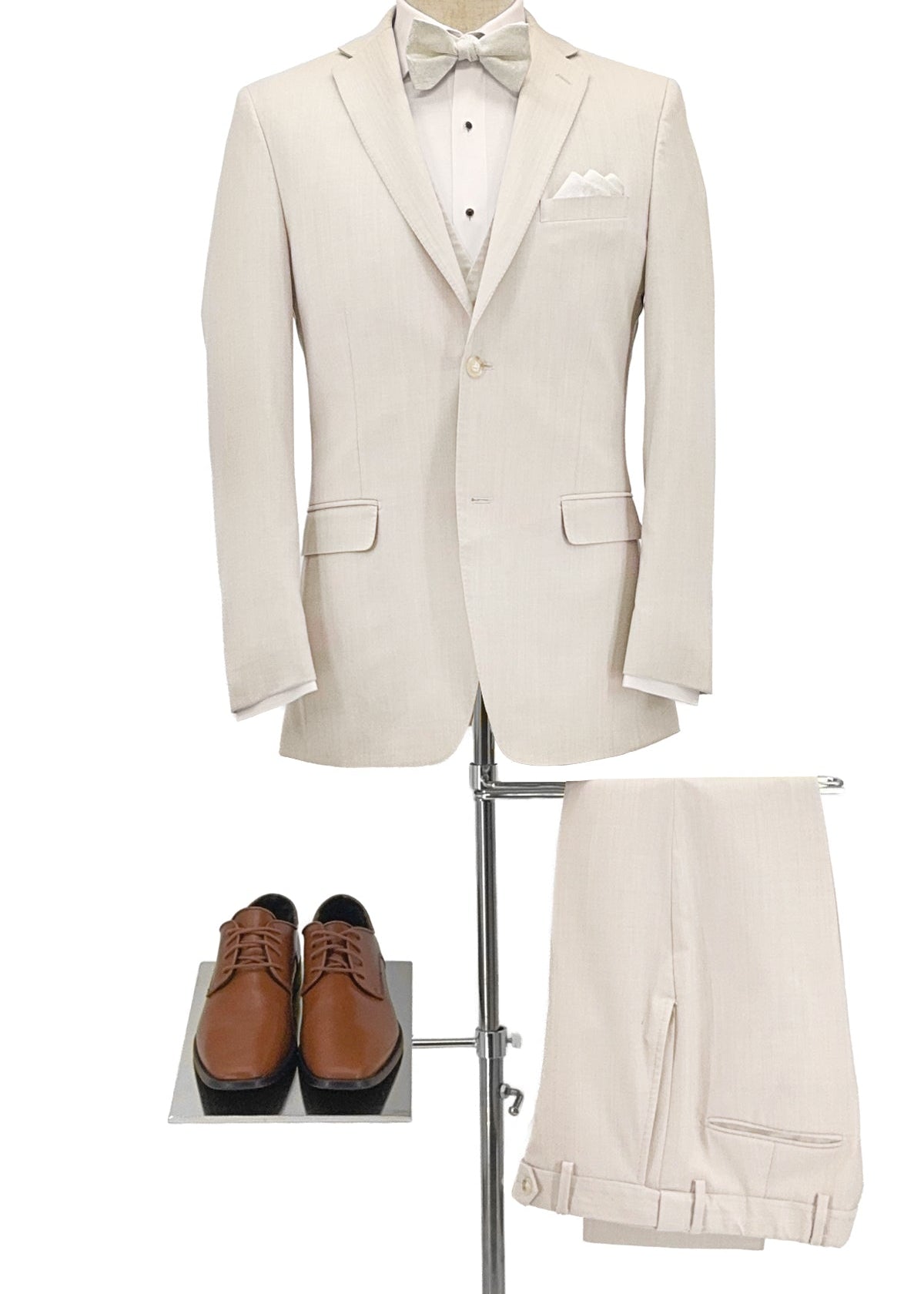 Beige suit with bow tie, white shirt, and brown shoes on a stand against a white background