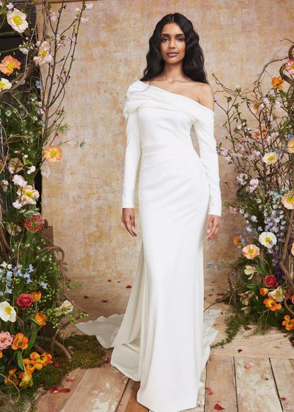 Young woman wearing an asymmetric neckling fitted wedding dress - FRONT VIEW