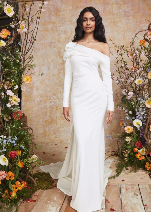 Young woman wearing an asymmetric neckling fitted wedding dress - FRONT VIEW