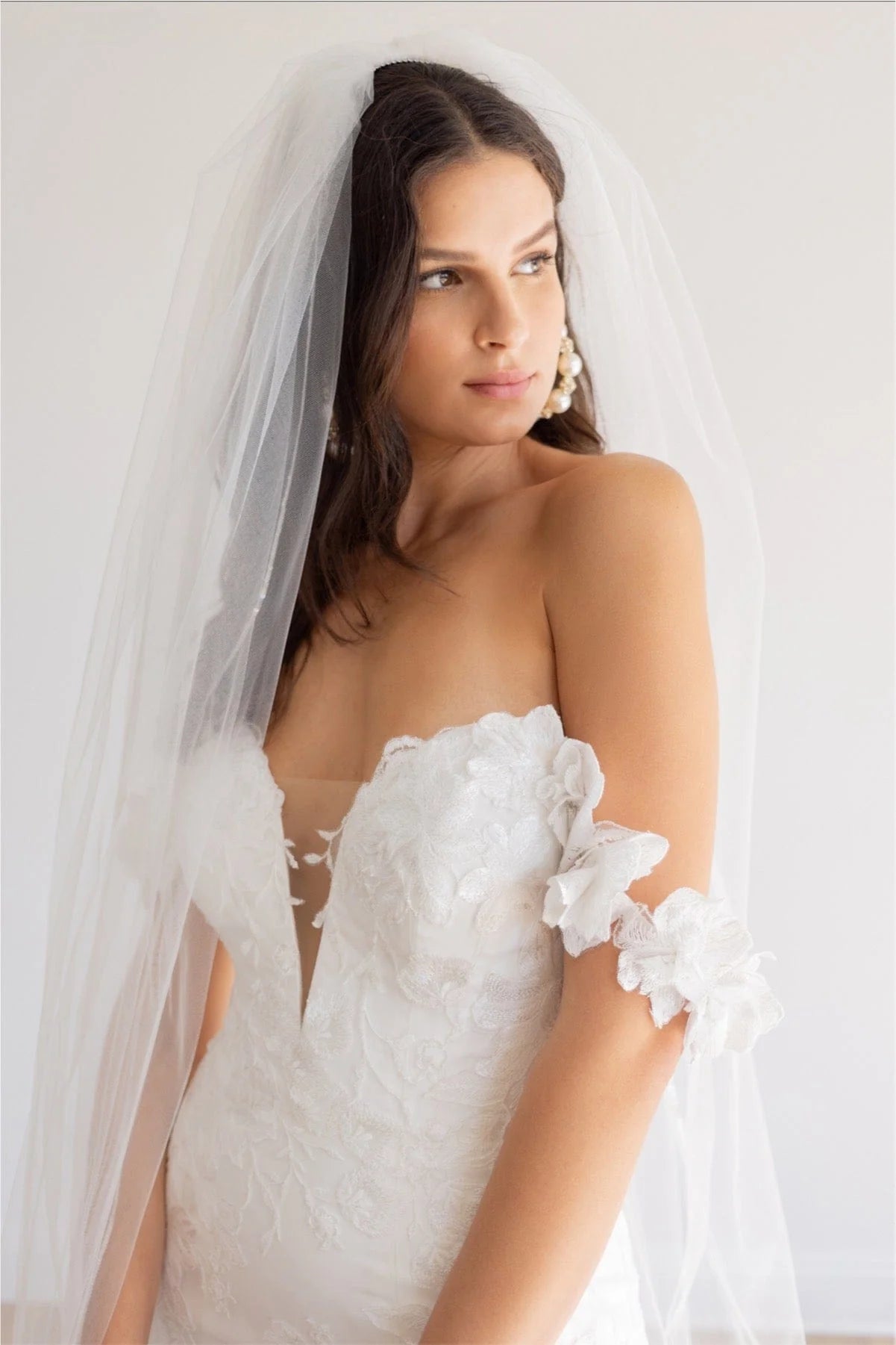 This fit and flare silhouette has gorgeous Camellia Floral Lace from head to toe. The Stretch Poly Charmeuse lining allows for comfort while her modern plunge and open illusion back show off your silhouette. Off the shoulder sleeves will give you the sleeve look without adding too much coverage.

