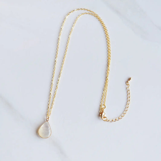 Mother of pearl necklace on a gold chain on a white backdrop