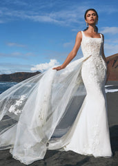 Young woman wearing a square neck wedding dress with floral lace - front view