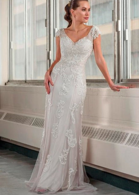 A young woman wearing a lace and sequined wedding dress