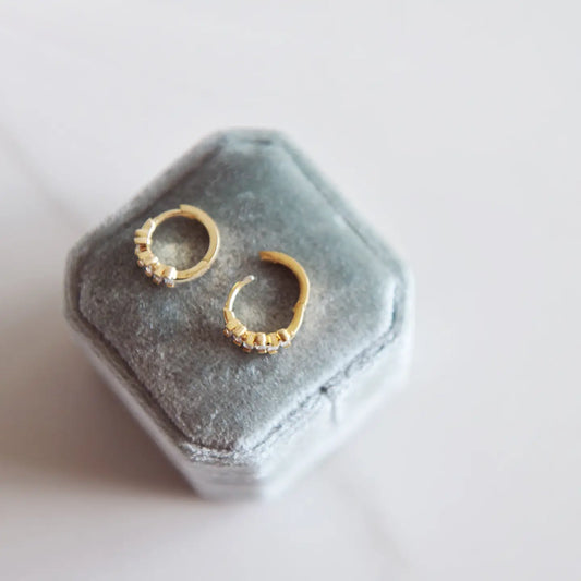 Sunny Huggie Hoops - gold mini hoops on a grey ring box