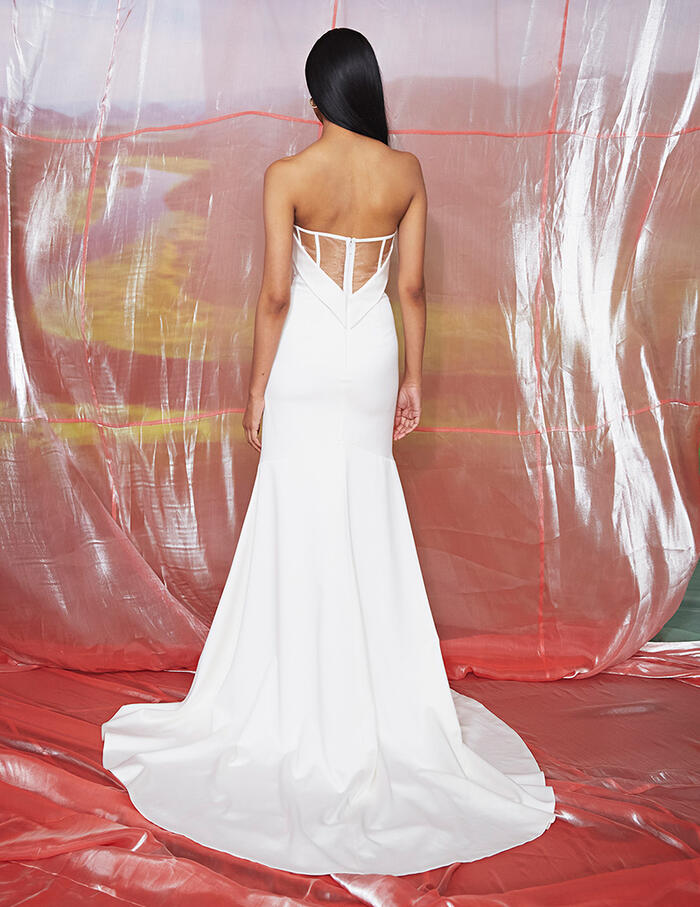 Model wearing Dove by Theia Couture - a strapless fit and flare wedding dress, - full body back view