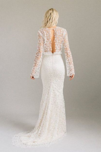 Shes a bell sleeved lace gown with a centre slit and a keyhole back