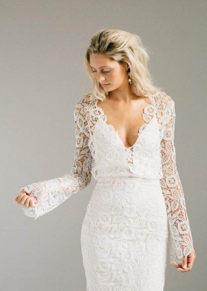 Shes a bell sleeved lace gown with a centre slit and a keyhole back