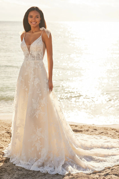 fairtytale whimsical a-line v-neck beaded tulle wedding dress with bow sleeves. Shown on the beach. 