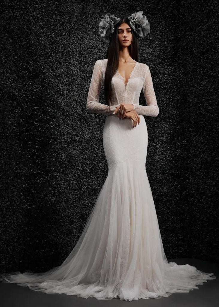 Model wearing Monique by Vera Wang - a mermaid lace wedding dress with long sleeves and a deep V, full body front view
