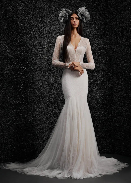 Model wearing Monique by Vera Wang - a mermaid lace wedding dress with long sleeves and a deep V, full body front view