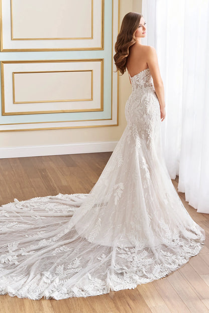 model showing off the back of strapless mermaid wedding dress with floral tulle and detachable sleeves, and a long strain available at NKIN