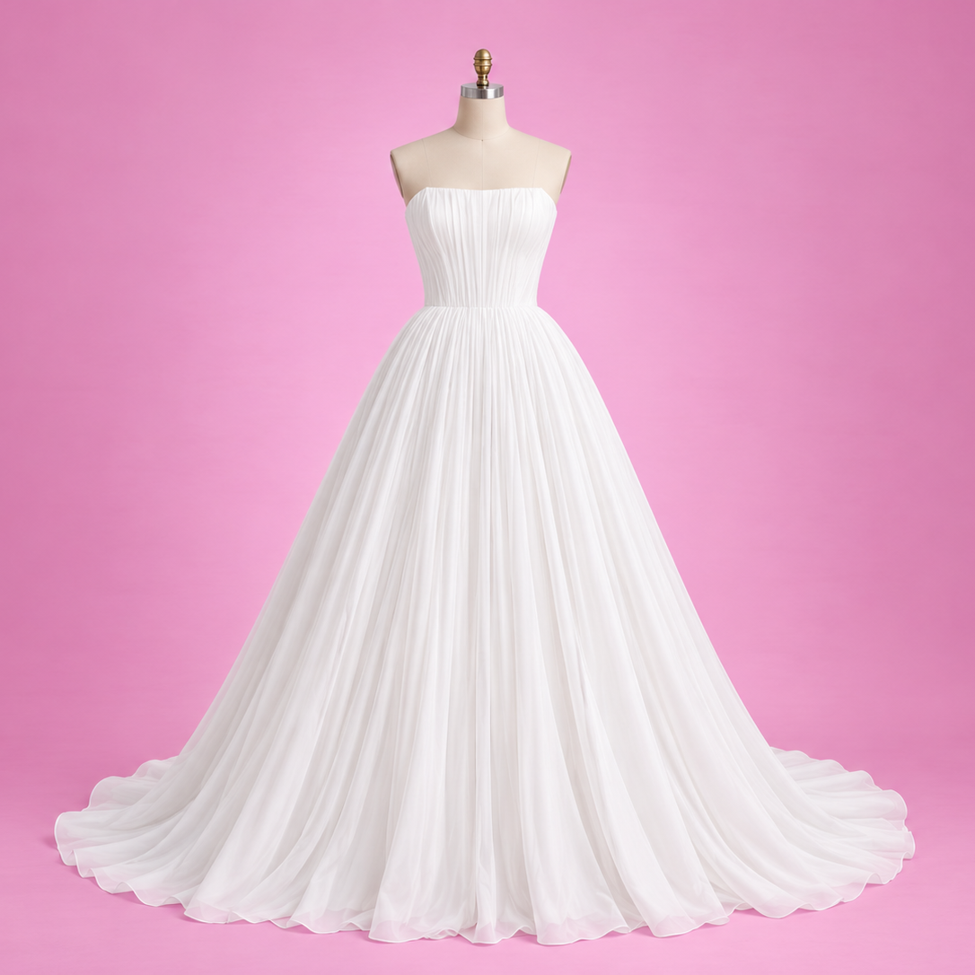 A strapless white A-line wedding gown displayed on a dress form mannequin against a solid pink studio background.