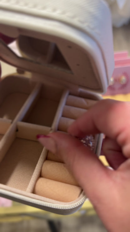 Putting earrings into a cream and bow colored jewelry box