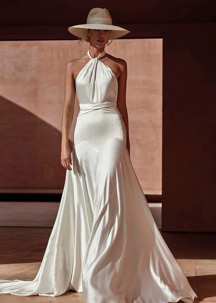 Model wearing Antalya by Pronovias -a a sheath halter neck wedding dress with an open back, full body front view