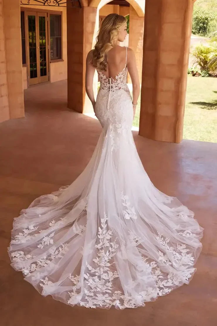 Model showing the low back and dramatic train of Ivana by Sophia Tolli is a fitted lace and tulle wedding dress at NKIN bridal boutique in Ottawa