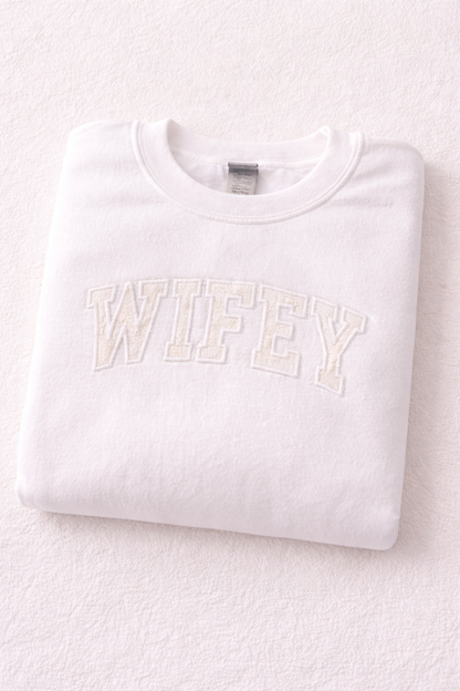 White sweatshirt with 'WIFEY' text on a light gray background, using wedding dress appliquee
