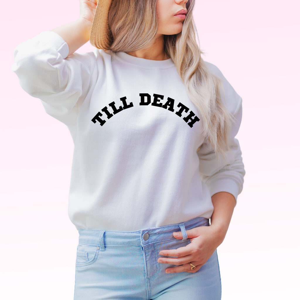 Young woman wearing a white crewneck with "till death" printed on it. A minimalist outfit/gift for the bride to be!