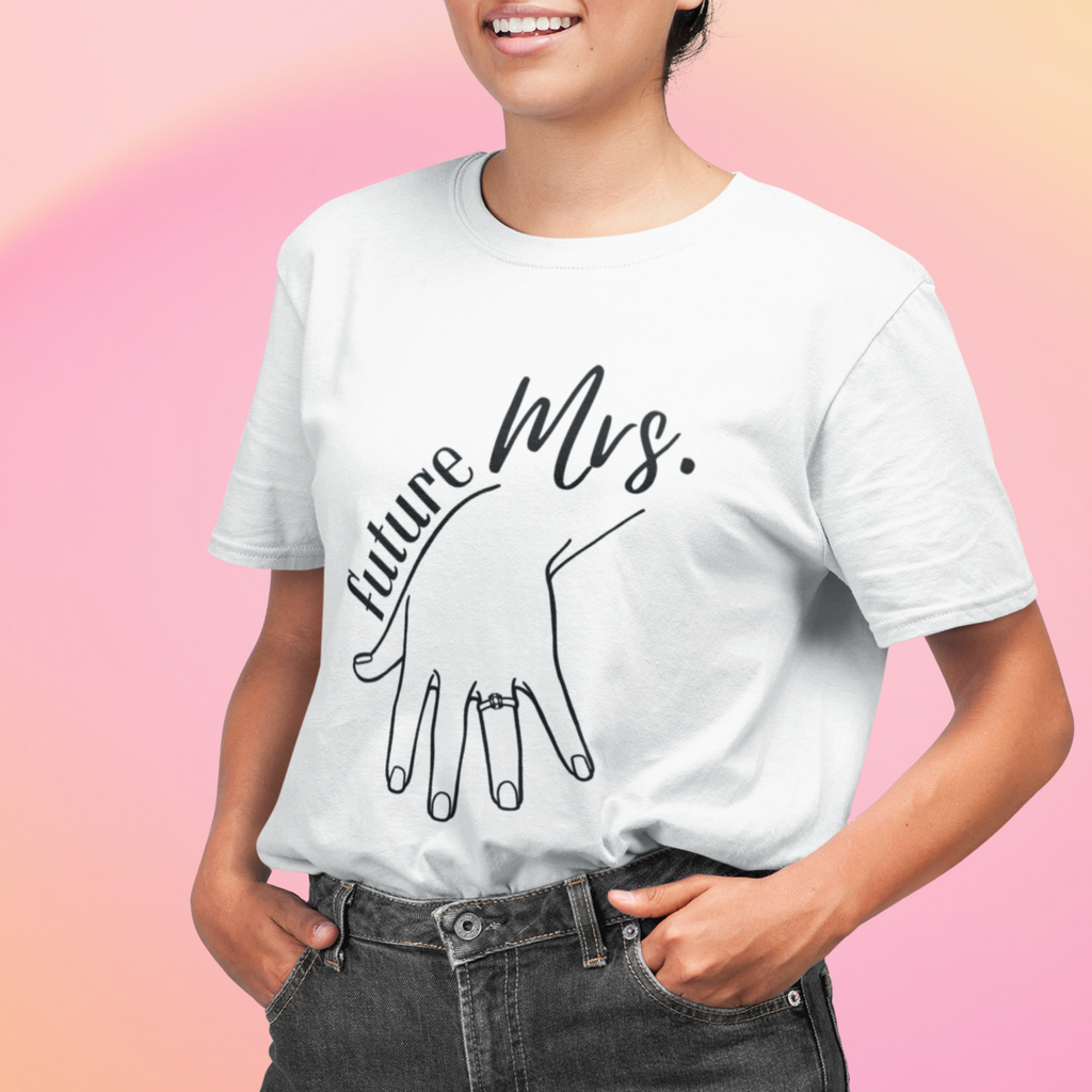 Young woman wearing a white t shirt with "future mrs" written on it with a hand and ring on her finger.