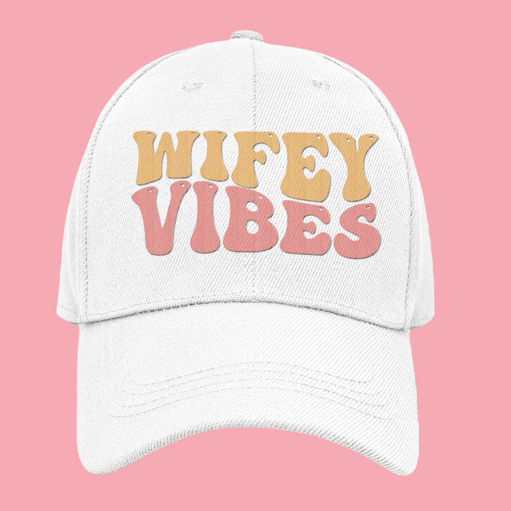 A white hat that says "wifey vibes" in retro pastel writing.