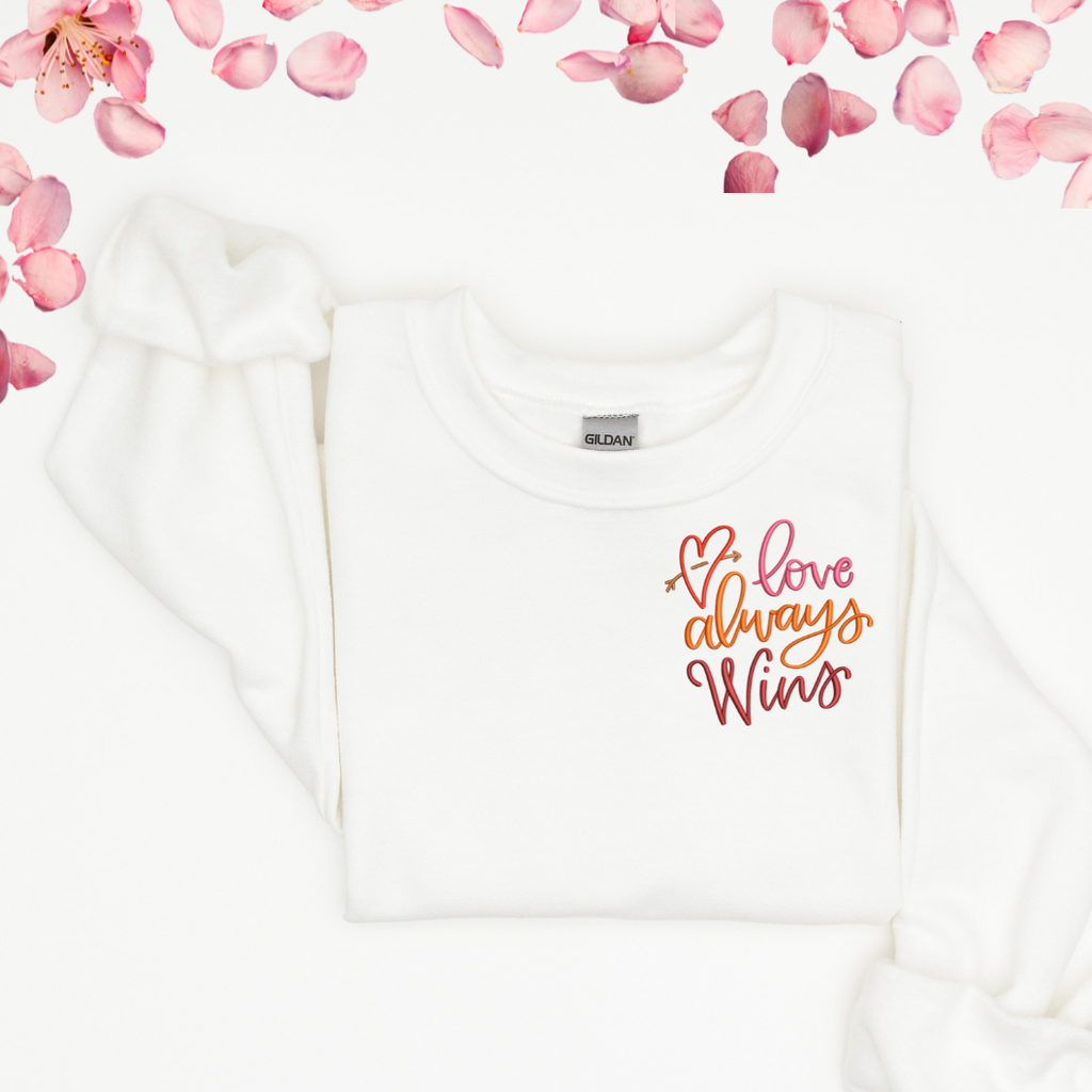 Sweatshirt with "love always wins" embroidered in the corner.