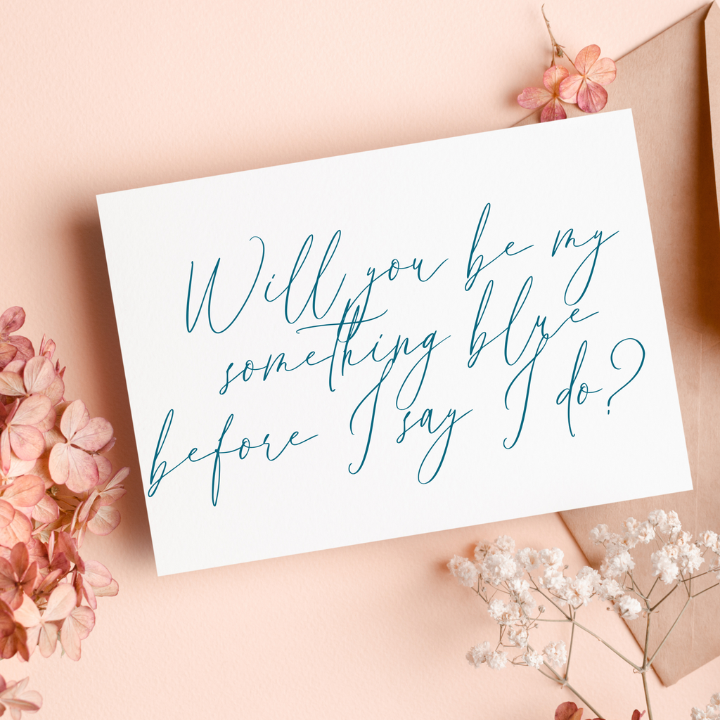 White card that says "will you be my something blue before I say I do?" written in blue