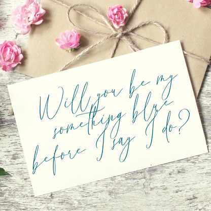 White card that says "will you be my something blue before I say I do?" written in blue