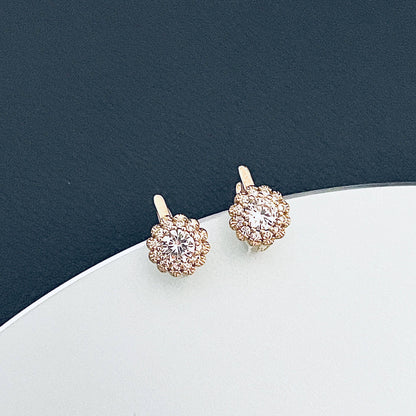 Small gold earrings with a floral shape