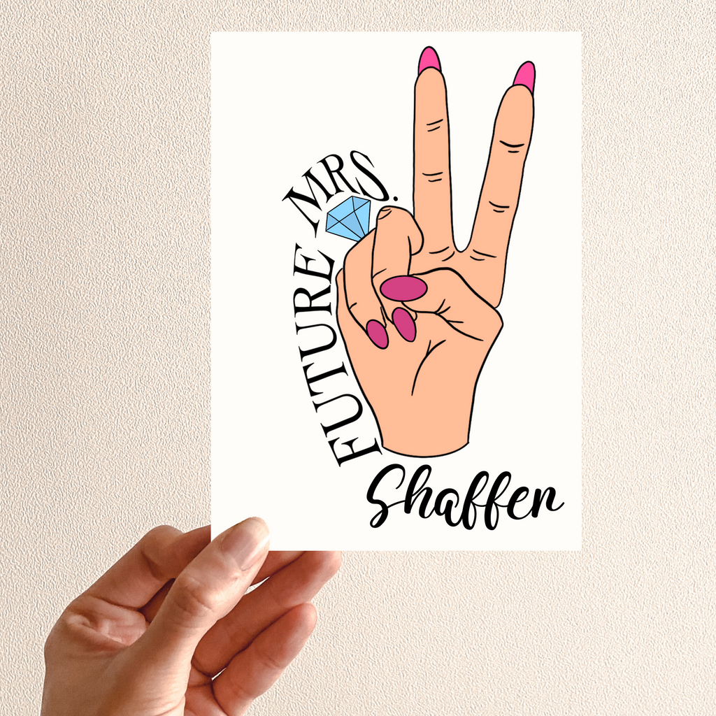 A personalized card, peace sign with a hand and pink nails with a ring on the fourth finger. Future Mrs Shaffer is written around the hand. A great personalized engagement gift for the newlywed.