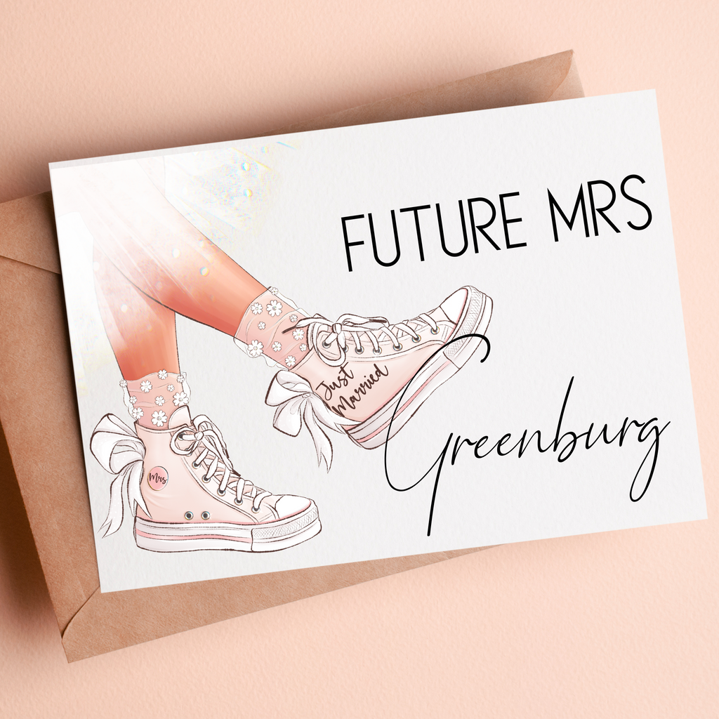 A custom "future mrs Greenberg" card with pink sneakers and "just married" featured on the side of the shoe. Set on a brown envelope and blush background. This is a great custom bridal shower card.