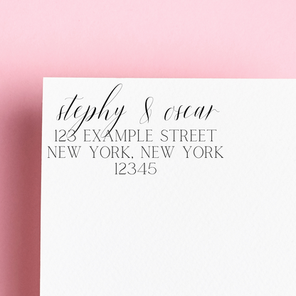 A self inking stamp on a white envelope. "Stephy & Oscar" written in calligraphy with the rest of the address written in block letters below. Sat on a pink background. A really custom, unique housewarming gift.