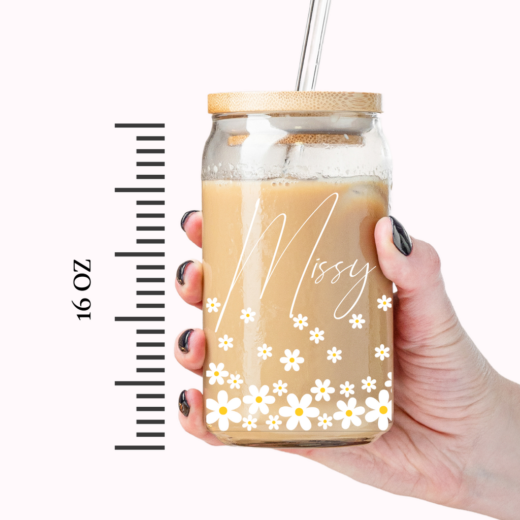 Simple glass coffee tumbler with "Ellie" written on it with daisy florals.