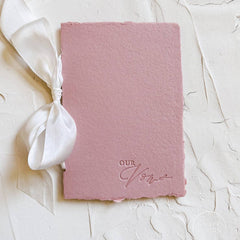 Pink vow book with white ribbon and 