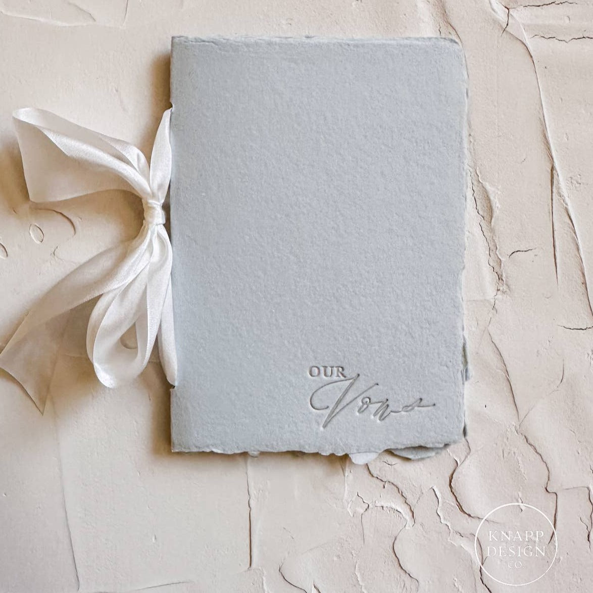 Blue vow book with white ribbon and 