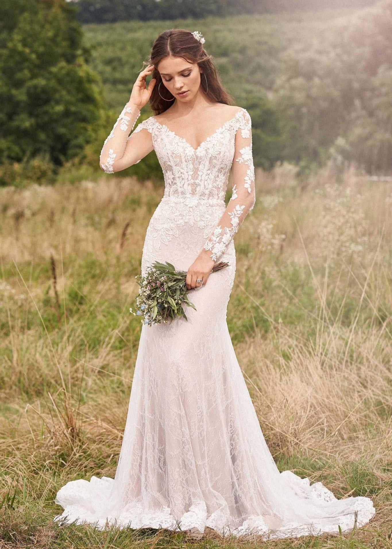 Woman wearing a long sleeve lace wedding dress holding a bouquet