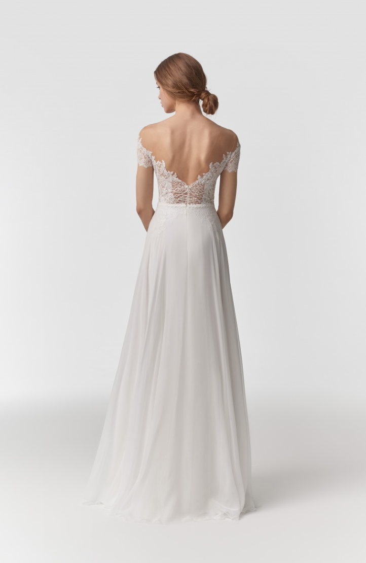 A backless, off-the shoulder, a-line gown with an illusion bodice, with added boning on the model