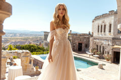 Closeup of model wearing elly bridal Belle dress featuring aline waistline, bustier top, and floral lace tulle