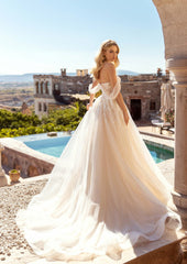 Back of model wearing Belle by Elle Bride showing off chiffon sleeves and oversized tulle ballgfown