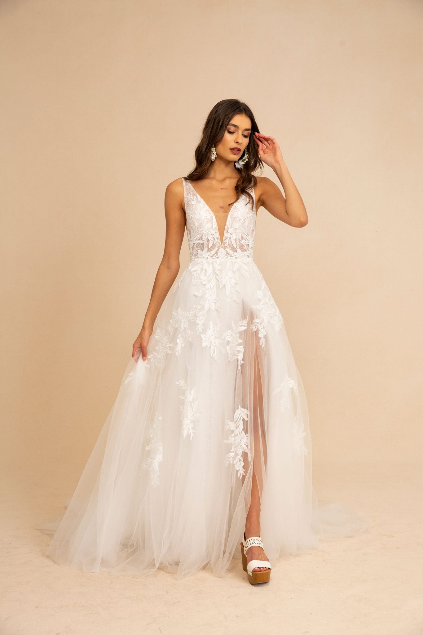 The Giuletta gown is a flirty A-line number featuring stunning lace applique detail adorned throughout the bodice and tulle skirt and a flirty side slit for the subtlest sexy touch.