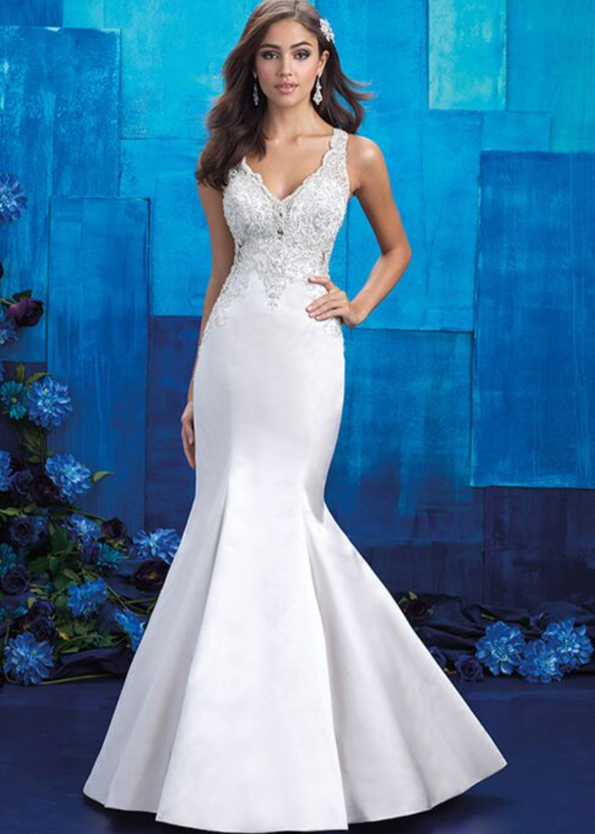 Woman wearing a white mermaid wedding dress with beaded on top - front view