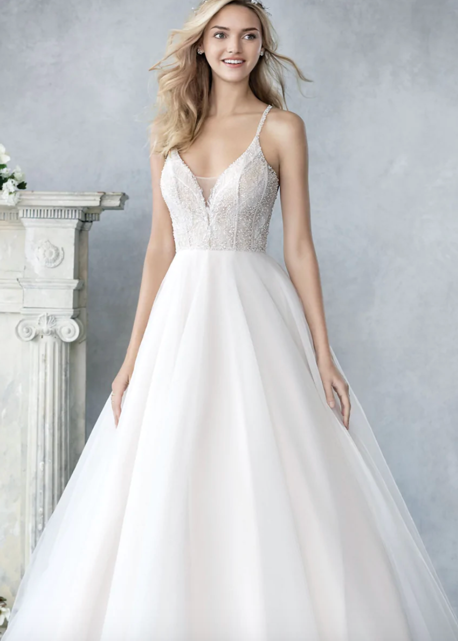 Woman wearing a ball gown wedding dress with a crystal beaded top - full body front view