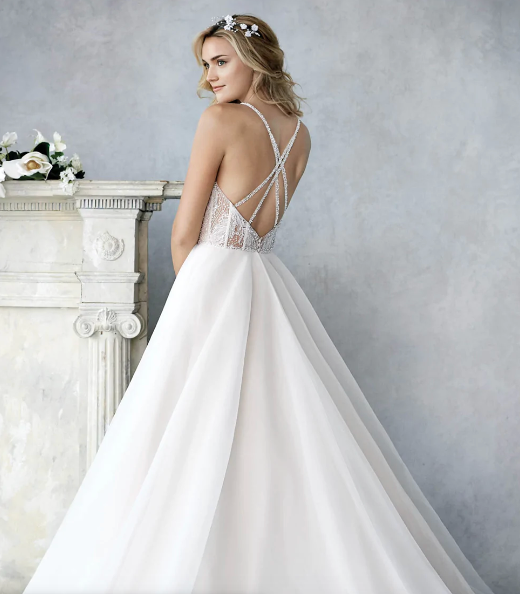 Woman wearing a ball gown wedding dress with a crystal beaded top full body back view