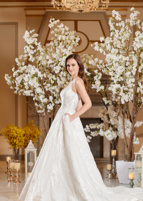 Model wearing Bella by Icon Bridal - a fully beaded ball gown wedding dress, full body side view
