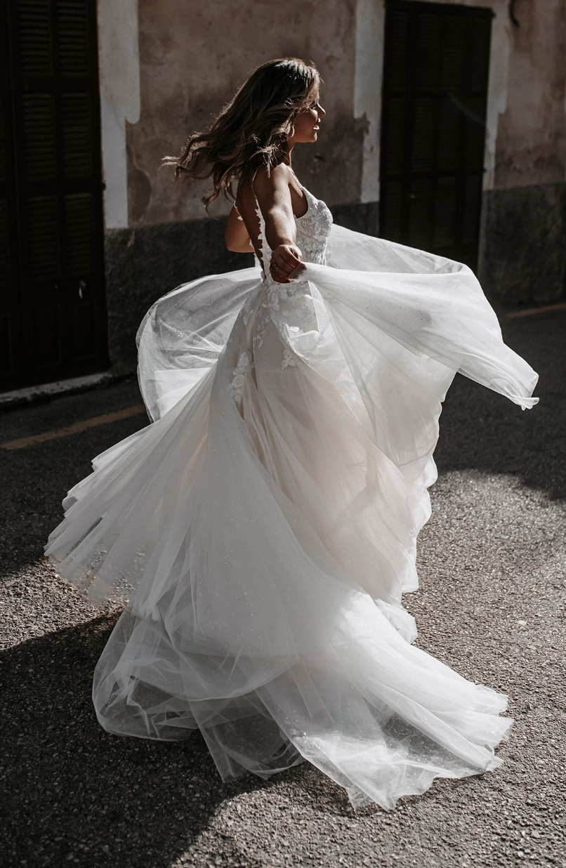 Dana Abella by Allure Bridal on model facing to the side with full tulle skirt