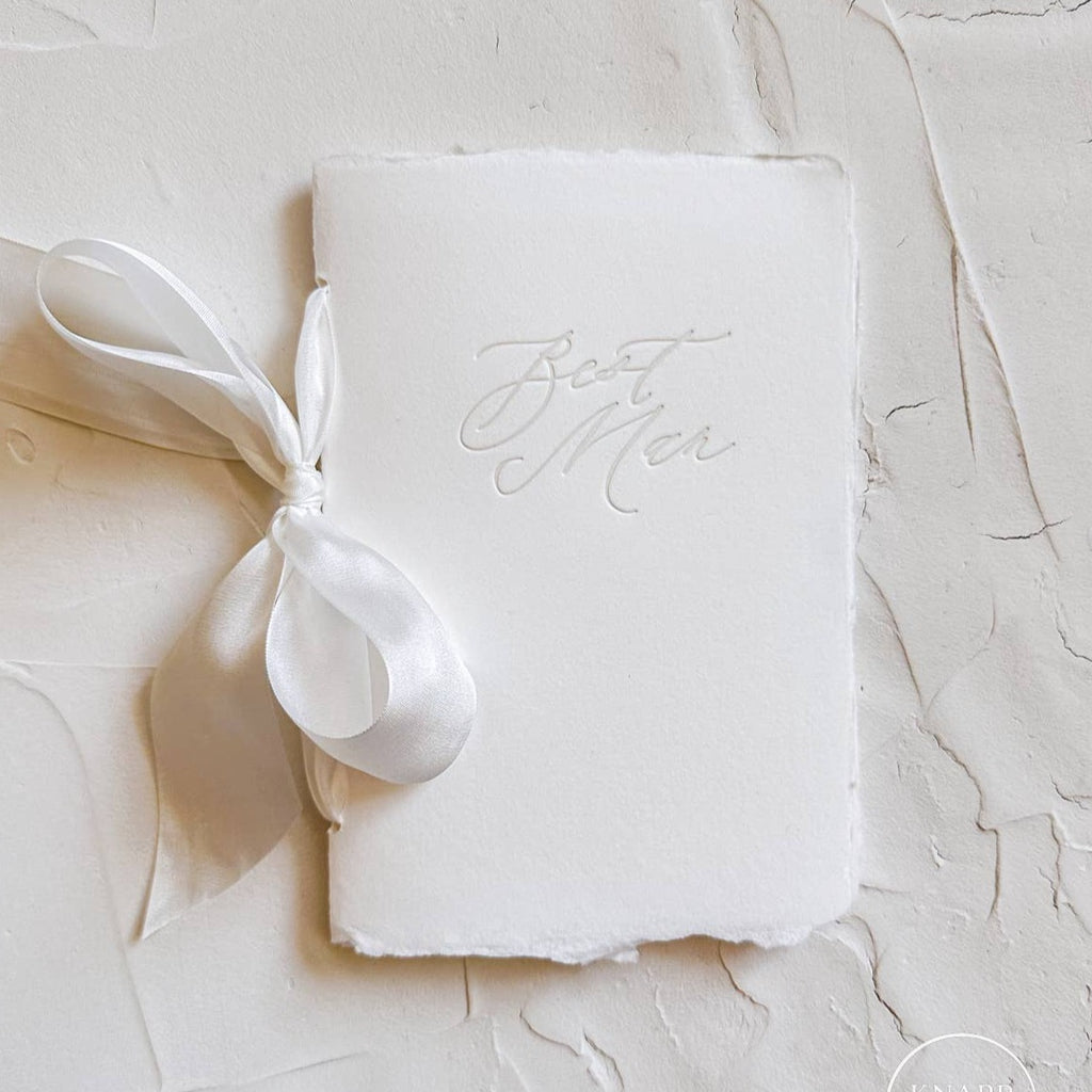 Picture of a white vow book with "best man" written on the front