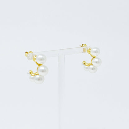 Close up photo of small gold hoops with pearls