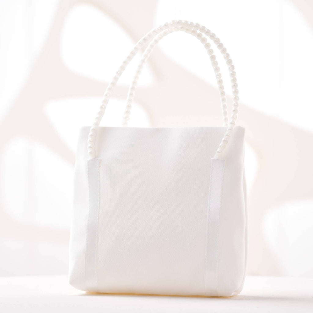 A simple white handbag with pearl handles.