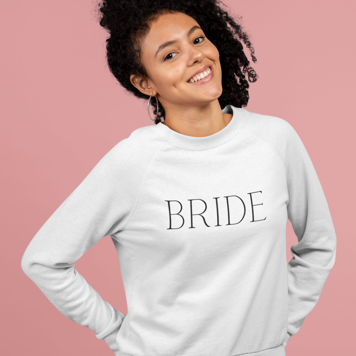 BRIDE written in black text on a white crewneck worn by a young woman