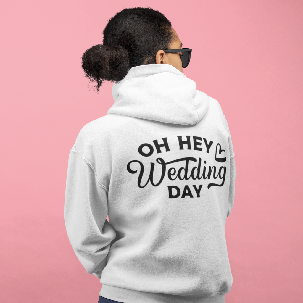 A back view of a white hoodie with "oh hey wedding day" printed in black