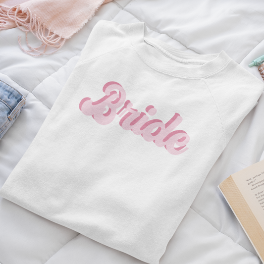 White crewneck with "bride" written in a pink vintage font - folded